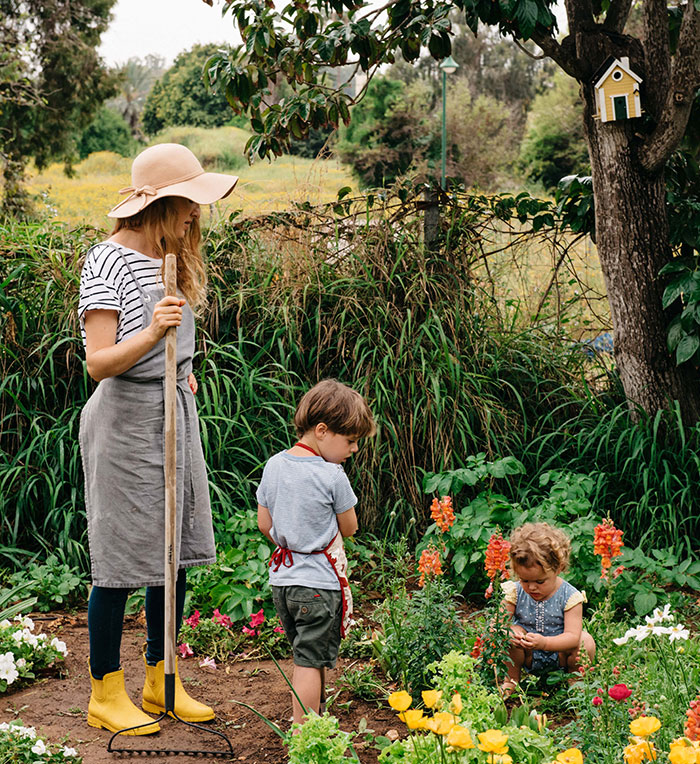 אבישג עובדת בגינת פרחים ושני ילדיה עובדים גם כן.